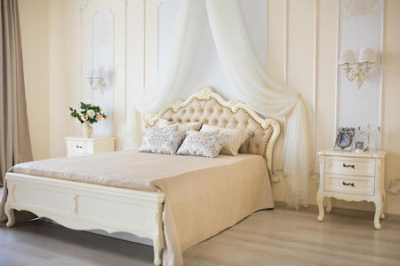 卧室采用柔和的浅色。 大舒适的双人床在优雅的经典内部