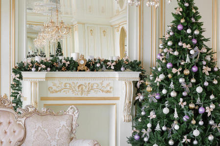 圣诞节早上。 经典公寓有白色壁炉，装饰树，明亮的沙发，大窗户