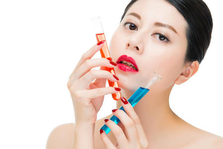 美丽的亚洲女人使用化学化妆品混合液体