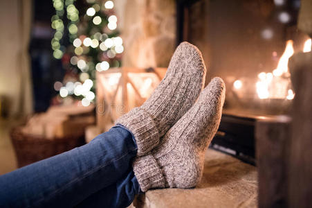 在圣诞壁炉旁穿着袜子的无法辨认的女人的脚
