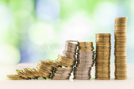 不断增长的硬币堆叠绿色和蓝色闪闪发光的波基背景。 金融增长，储蓄，商业金融财富和