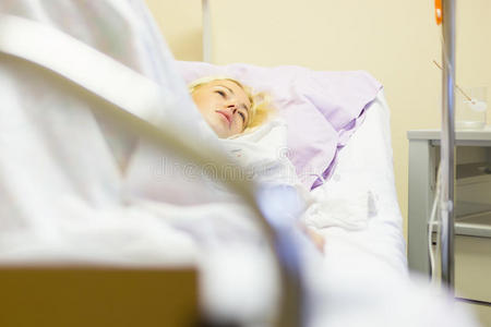 卧床不起的女性患者在医院护理中手术后恢复。