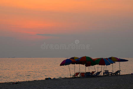 日落时间海滩上的沙滩椅子。