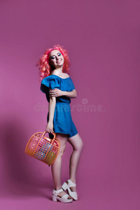 粉红色头发的女孩穿着蓝色连衣裙，带着紫色背景的袋子，放在文字的地方