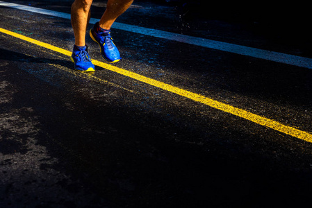 落日时分，一个孤独的跑步者在潮湿的柏油路上训练，复制空间。