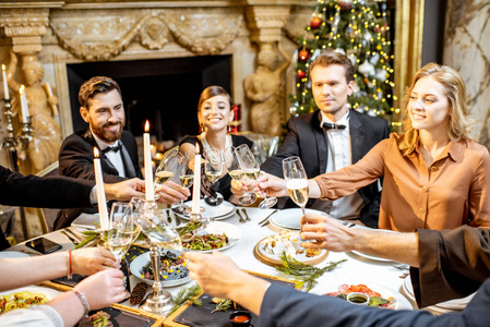 Elegantly dressed people celebrating New Year holiday indoors