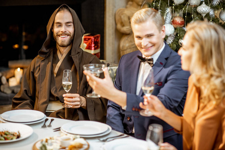 Elegantly dressed people having a festive dinner indoors