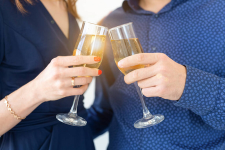 一对男人和女人用香槟庆祝圣诞或新年夜聚会的特写镜头。