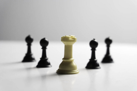 Chess piece standing out from others on light background. 