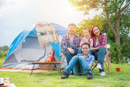 快乐的亚洲家庭坐在帐篷前露营