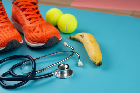 Orange sports shoes and stethoscope on the blue background. 