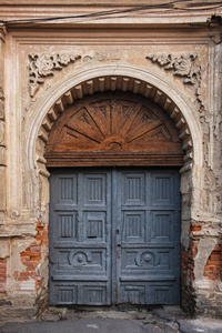装饰华丽的墙上有一扇古老的拱形木门