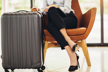 Business woman sitting in airport and waiting for her flight 