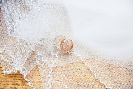 白色面纱上的金色结婚戒指图片