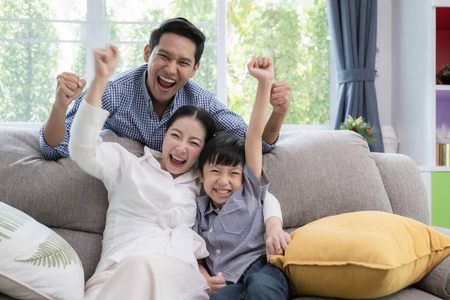 亚裔家庭的父亲，母亲和儿子微笑感觉激动人心
