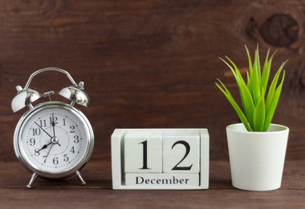 12月12日，在一个白色日历旁边的一个乡村木背景闹钟