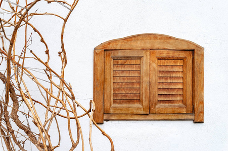 Wooden window and dry grapes of grapes on a white wall. Window c