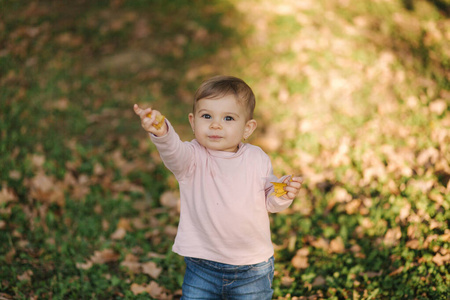 可爱的小女孩十月在公园散步。可爱的十个月婴儿散步。美丽快乐的女孩。秋天的心情
