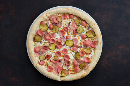 披萨的俯视图，有法兰克福香肠火腿腌黄瓜和洋葱
