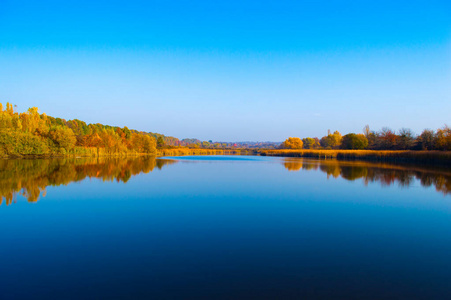 蓝天秋树倒映的美丽湖泊图片