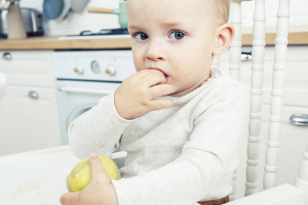 小可爱的小男孩早上坐在厨房的椅子上，生活方式让人有概念