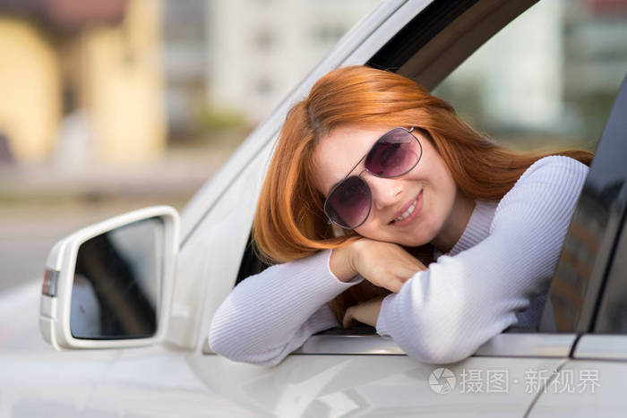一个红头发的年轻女人在开车