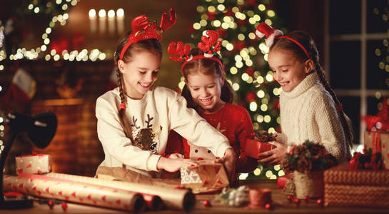快乐有趣的孩子女孩们晚上在荷包圣诞礼物