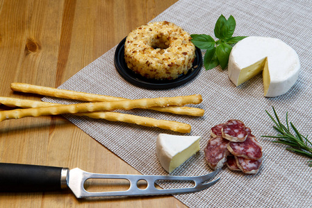 奶酪开胃菜或奶酪和葡萄酒宴会桌。布里奶酪面包棒和萨拉米香肠是开胃菜。