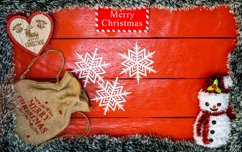 红色木板上的圣诞构图，上面有圣诞花环