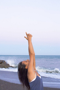 年轻的女运动员在沙滩上练习瑜伽