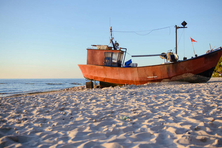 日出时海滩上的渔夫船图片