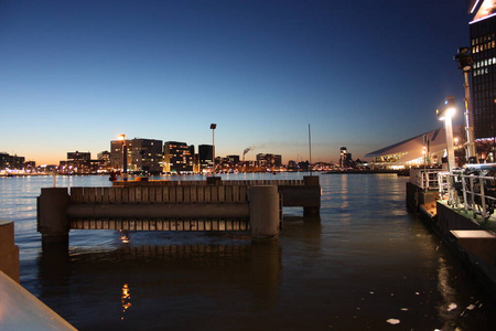 荷兰首都阿姆斯特丹运河水域的浪漫的秋夜全景，在建筑物和摩天大楼的灯光和照明中