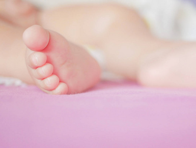 小宝宝的脚。没有什么比小小的小脚更甜美的了。小男孩躺在床上。闭合。复印空间。