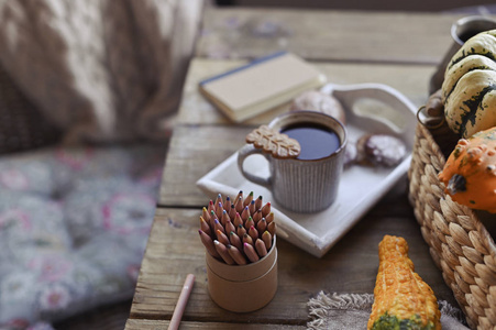 秋天，南瓜，热气腾腾的咖啡杯放在木桌上。季节性，早晨咖啡，周日放松和静物概念。一天的计划。