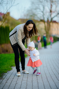 Happy mother and daughter in the park. Beauty nature scene with 