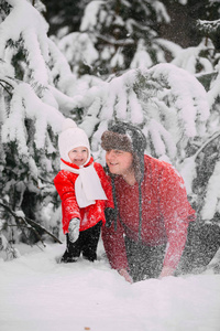 图为穿着红色外套的快乐小女孩和爸爸在冬天的森林里玩雪。和爸爸玩的女孩。