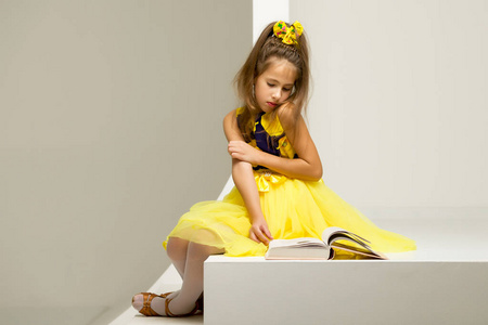 一个小女孩坐在楼梯上读博