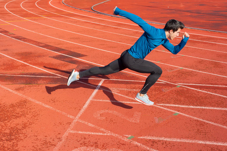 Runner starting his sprint on running track in a stadium. 