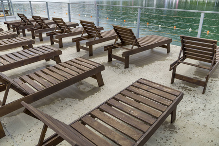 一排空的木制沙滩椅靠近水面。