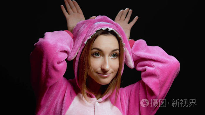 穿着连体衣的滑稽女孩kigurumi在黑色背景上跳舞