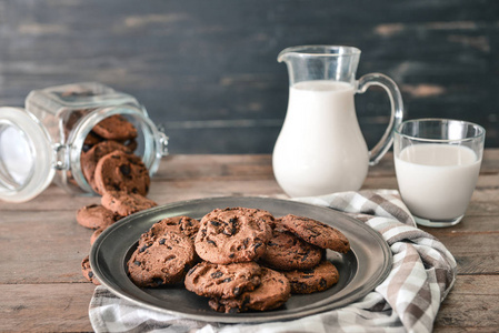 木桌上放着牛奶的美味巧克力饼干