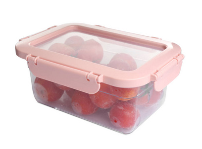 冷冻西红柿在塑料容器隔离白色。蔬菜