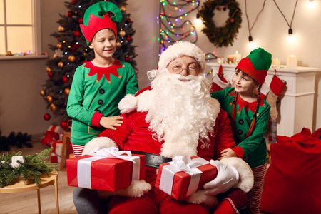 圣诞老人和小精灵孩子们在装饰圣诞礼物的房间里