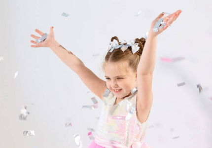 派对，假日，生日，新年和庆祝概念可爱的孩子扔五彩纸屑。