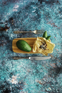 Avocado cooking recipes. Ripe green avocado on a wooden cutting 