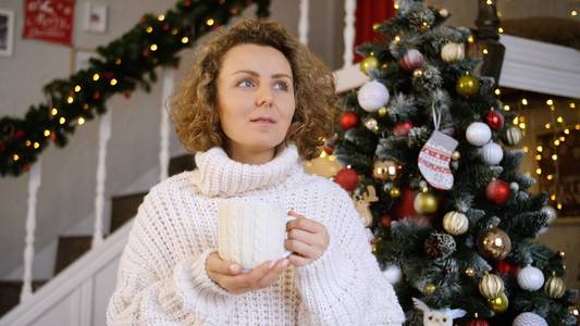 圣诞节，假日和人的概念快乐的年轻女人在家里喝一杯热巧克力。