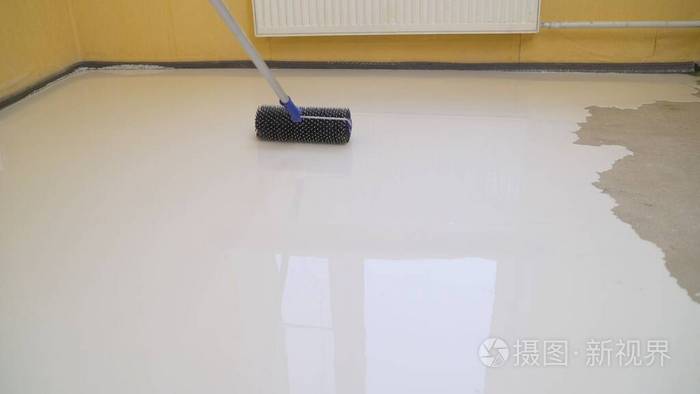 用压路机把地板找平公寓的内部正在施工自流平地板镜面光滑的地板表面