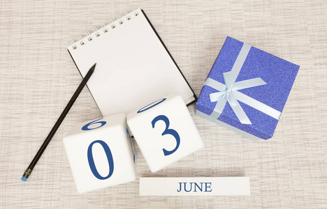 日历上有时尚的蓝色文字和6月3日的数字，还有一个盒子里的礼物。