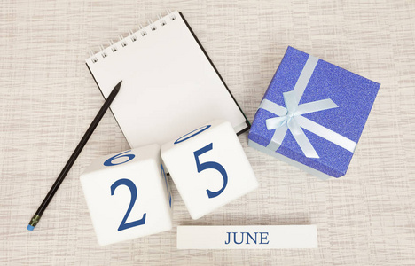 日历上有时尚的蓝色文字和6月25日的数字，还有一个盒子里的礼物。