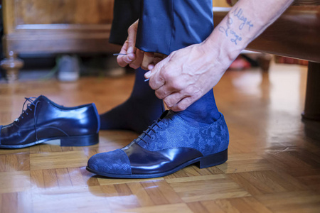  groom tying his shoes for his wedding